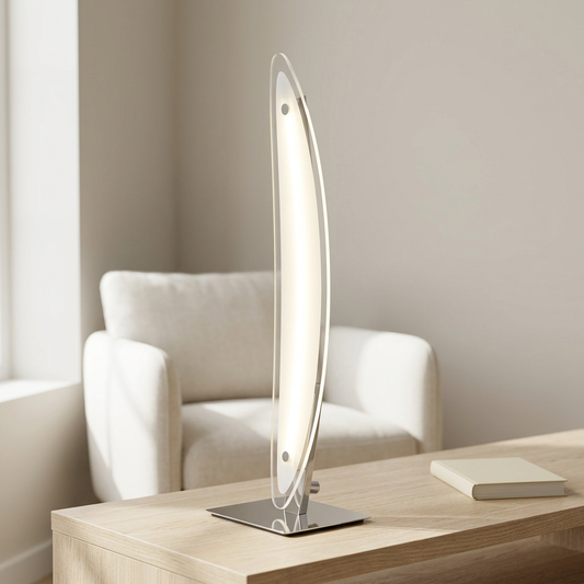 LED-Tischleuchte SURF mit schlanker geschwungener Lichtfläche, warmweißem Licht und quadratischem Chromfuß auf einer hellen Holzkonsole vor einem cremefarbenen Sessel.